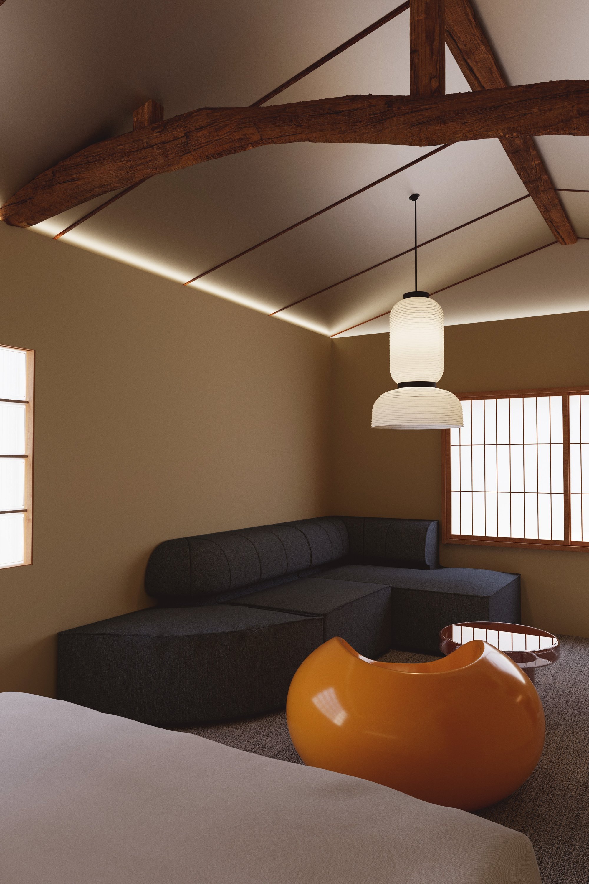 Timber beams rise above a curved charcoal sofa.